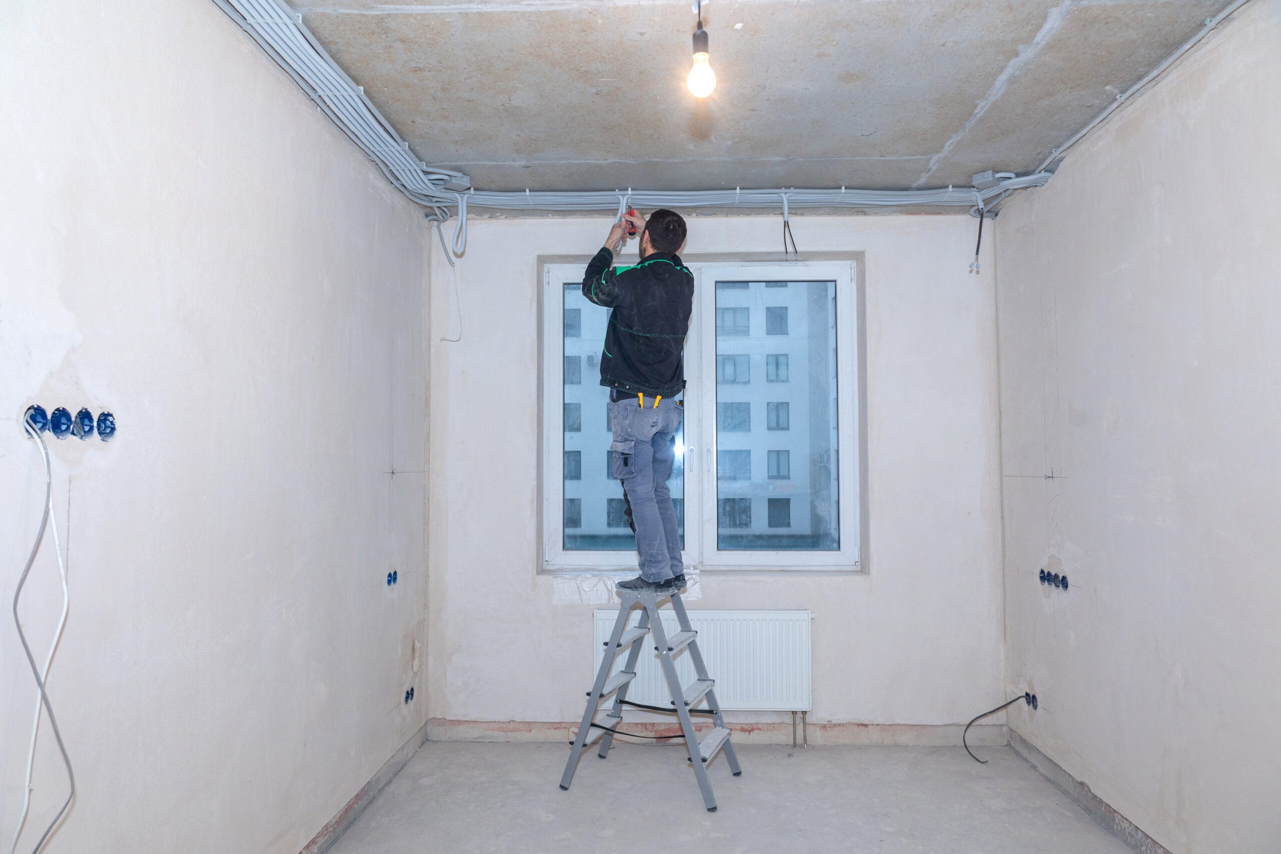 Electrical worker checks voltage in wires. Repair in new apartment, electricity wiring. High quality photo