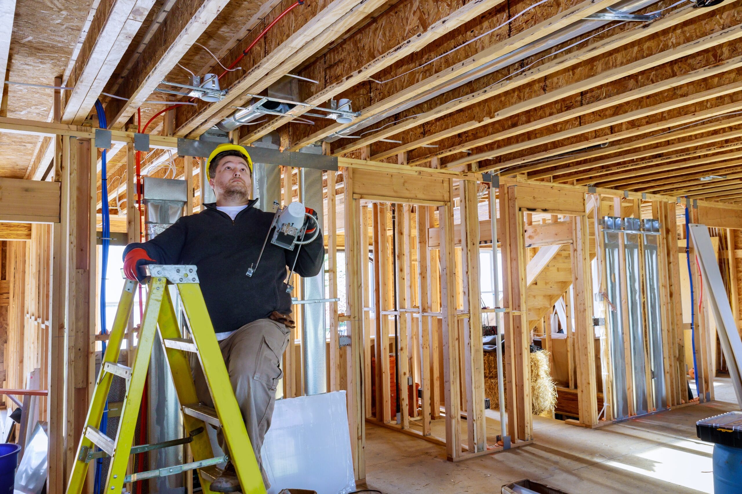 Electrician is holding in his hands installs and mounts the interior lighting on the ceiling